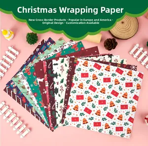 Flat lay of Christmas scrapbook paper with gingerbread and Santa Claus festive patterns