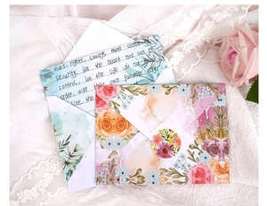 Detailed view of floral watercolor envelopes with matching letter paper and seals