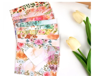 Detailed top view of assorted floral watercolor envelopes with tulip accents on white