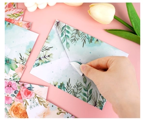 Detailed view of floral watercolor envelopes with matching round sealing stickers