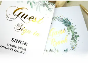 Detailed view of the gold-foiled Guest Book and sign-in card with green floral motifs