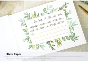 Detailed view of cream guest book with green leaves design, gold pen and stickers