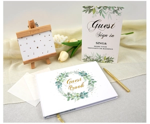 Wedding guest book set with gold pen, sign, and mini easel on a linen background
