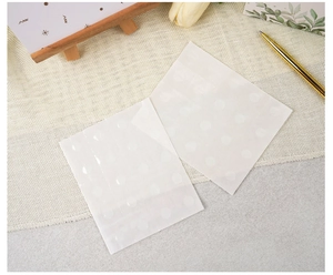 Detail of clear double-sided adhesive glue dots for guest book assembly on burlap