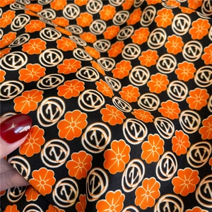 Detail view of the floral twill fabric showing orange flowers and Z patterns