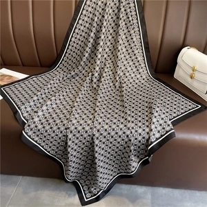 French style silk scarf with black and white floral pattern on brown leather bench
