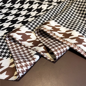 Close-up of houndstooth silk scarf showing premium texture and fine hemmed edges