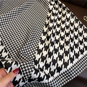 Detail of classic black and white houndstooth pattern scarf with spliced fabric texture
