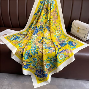 Détails de texture du foulard en soie jaune 90cm avec motifs floraux sur un canapé