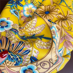 Détail du foulard en soie sergé jaune montrant les motifs floraux et la texture douce