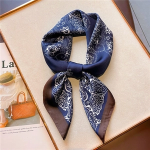 Navy and brown paisley silk scarf displayed on a beige board with fashion magazine