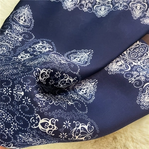 Detailed shot of navy paisley silk scarf with glossy texture and fine kaleidoscope patterns