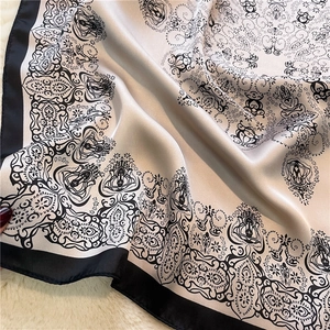 Close-up of champagne square silk scarf with paisley pattern on soft faux fur