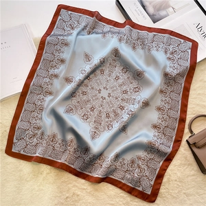 Macro shot of paisley silk scarf with blue patterns and brown border on faux fur background