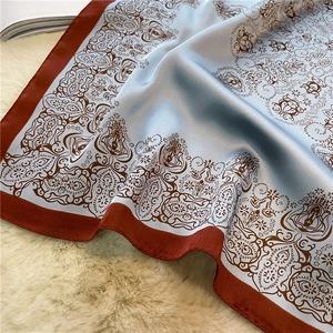 Detail of blue and red paisley silk scarf on plush rug with elegant satin finish