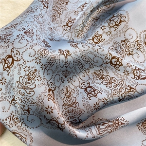 Close-up of blue silk-like scarf with vintage paisley mandala print and smooth texture