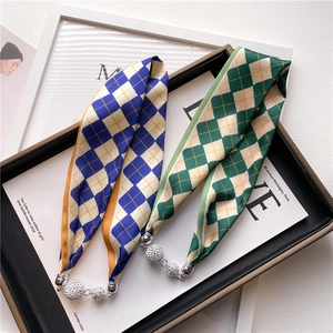 Détail de foulards à carreaux avec sphères argentées serties de diamants sur plateau