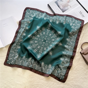 Detail of dark green satin scarf with white vintage mandala pattern on plush rug