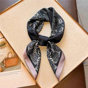 Detail of silk square scarf featuring black paisley patterns and lavender borders