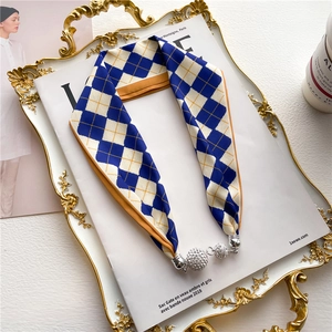 Collier foulard en soie à carreaux avec pendentifs boules argentées sur plateau chic