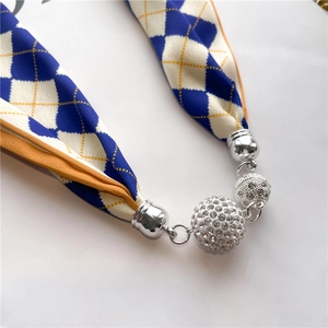 Détail du collier foulard en soie à losanges avec sphères en strass et accents argentés