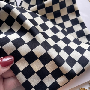 Détail du tissu satiné à carreaux du foulard montrant sa texture soyeuse et drapée