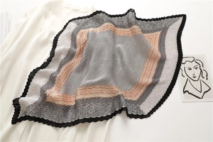 Détail d'un foulard en soie plissé aux motifs géométriques gris et orange élégants