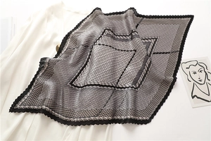 Détail d'un foulard en soie plissé à carreaux avec motif géométrique et bords ondulés