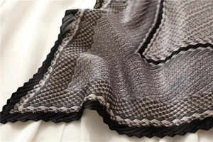 Vue macro détaillée du foulard plissé en soie avec motif pied-de-poule classique noir et blanc