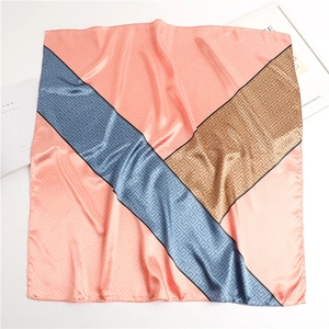 Detail showing geometric color-block satin scarf with classic Greek key patterns