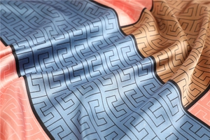 Close-up of geometric Greek meander pattern on premium satin silk scarf with elegant folds