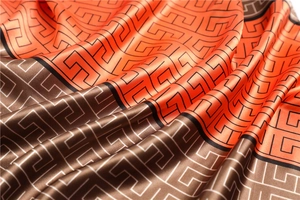 Macro detail of satin silk scarf showing geometric patterns and smooth glossy fabric