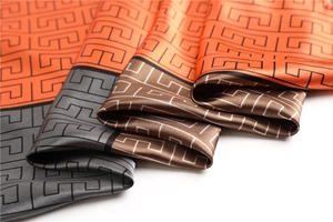 Close-up of satin silk scarf with Greek Key patterns in orange, grey and brown colors