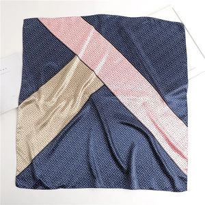 Detail of satin square scarf featuring navy and pink geometric patterns and labyrinth texture