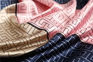 Detailed view of satin scarf showing geometric greek key pattern and silk-like sheen texture