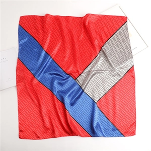 Detail of silk-like satin square scarf with red, blue, and grey Greek key pattern