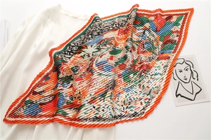 Dettaglio di un foulard plissettato in seta con stampe astratte colorate e bordo arancione