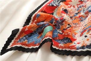 Dettaglio di un foulard in seta a pieghe con stampe astratte colorate e bordi neri