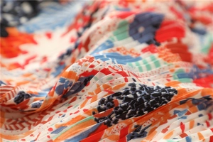 Dettaglio del foulard in seta a pieghe con motivo floreale astratto e trama fine