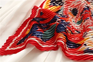 Dettaglio ravvicinato di un foulard in seta arancione con stampe d'arte astratta