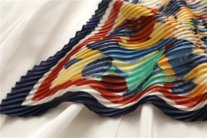 Dettaglio della trama a pieghe e della stampa artistica su foulard di seta