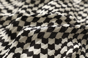Macro shot showing pleated texture of black and white checkered geometric scarf fabric