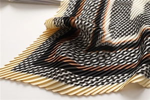 Close-up of plissé houndstooth scarf showing geometric patterns and pleated texture