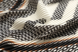 Macro view of pleated black and white checkered scarf with orange border lines