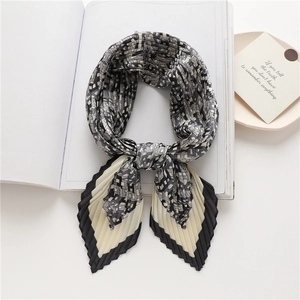 Macro detail of pleated black and white checkered scarf with geometric monogram pattern