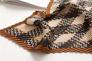 Close-up of pleated scarf featuring houndstooth geometric pattern and accordion texture