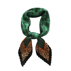 Pleated silk scarf with green floral and leopard print design in a tied knot style