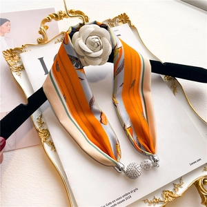 Detail of silk scarf necklace with a white camellia flower and rhinestone sphere pendants