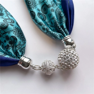 Détail de bijoux en soie avec motif mandala turquoise et fermoir magnétique en strass