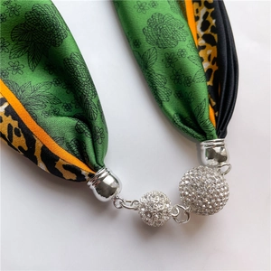 Détail du collier écharpe en soie avec imprimé léopard floral et pendentifs strass